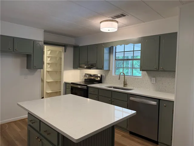 This kitchen offers ample storage and a functional island for culinary pursuits.