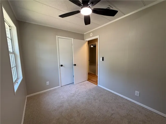 This inviting bedroom features soft carpeting and ample natural light, creating a comfortable living space.