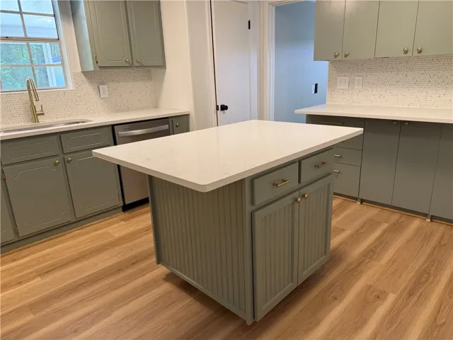 This bright kitchen offers functional design, sleek countertops, and ample cabinetry for culinary ease.