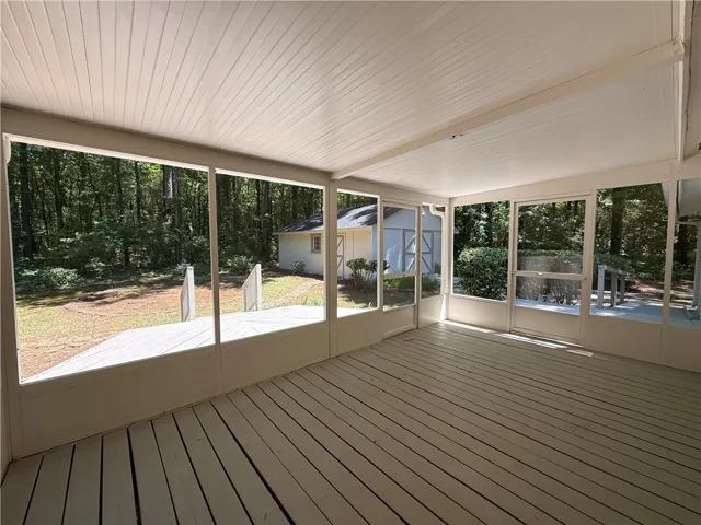 This inviting screened porch provides a tranquil connection to the expansive outdoor landscape.