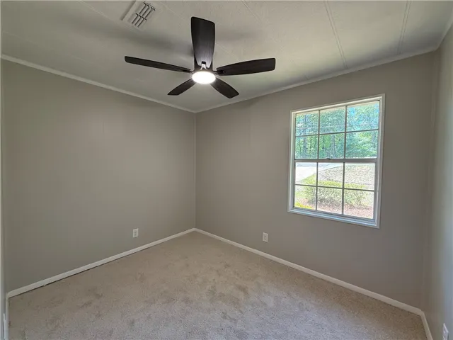 This cozy bedroom offers comfort and a tranquil view of nature through its large window.