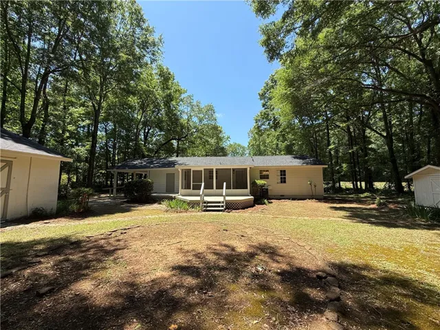 This charming home offers a serene woodland setting with a spacious backyard and inviting screened porch.