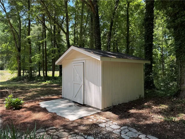 This outdoor shed provides functional storage amidst a tranquil, wooded setting.