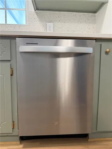 This kitchen showcases a modern dishwasher and classic cabinetry, creating a functional and stylish space.