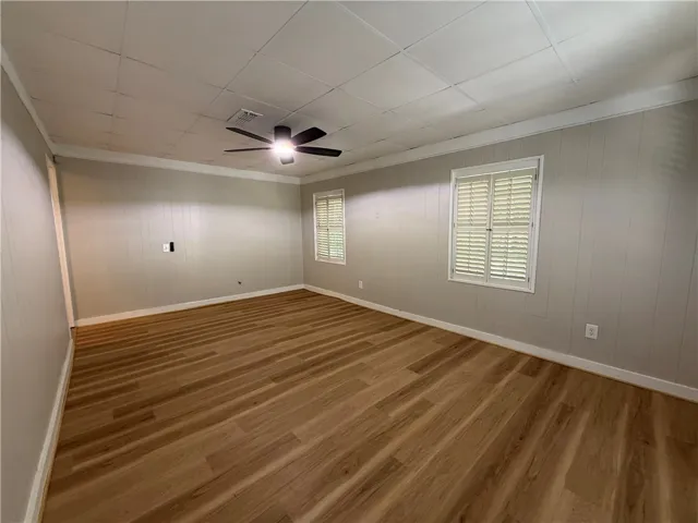This bright room features durable flooring, ample natural light, and a refreshing ceiling fan.