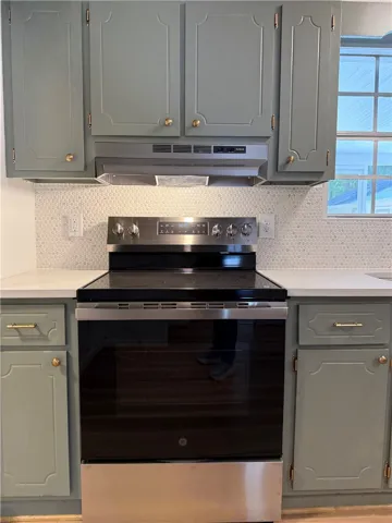 This modern kitchen features a sleek electric range and ample cabinetry, offering both style and functionality.