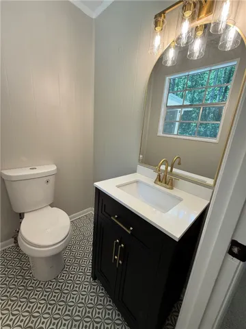This thoughtfully designed bathroom offers a stylish vanity and unique patterned flooring.