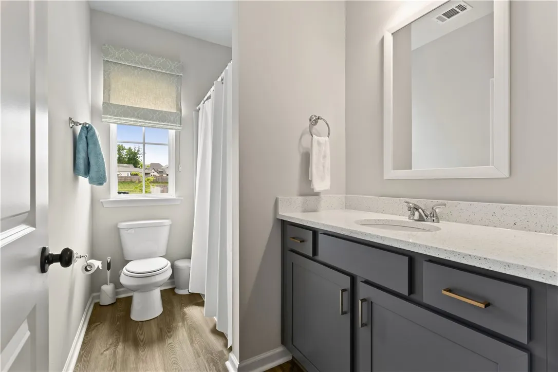 This bathroom features a sleek vanity with ample storage and durable flooring.