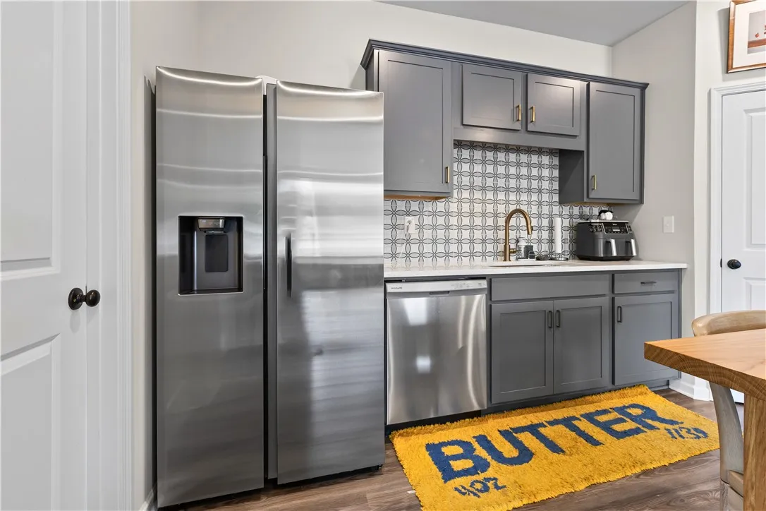 This modern kitchen features sleek appliances and elegant cabinetry with upscale backsplash.