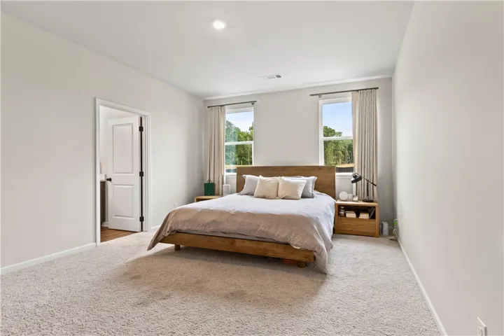 This primary bedroom is spacious and  offers a tranquil retreat with ample natural light.
