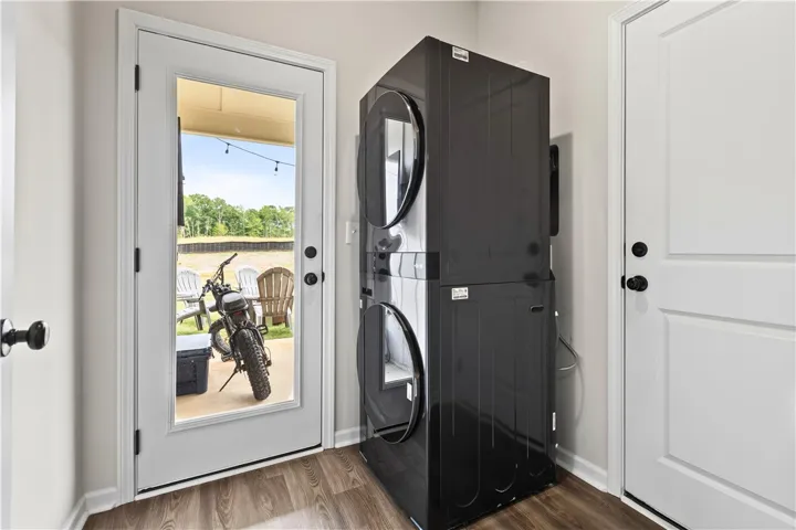 This laundry area features a convenient washer/dryer stacked unit, simplifying everyday chores. The laundry has  access to single car garage and patio with tv outlet and decorative lights.