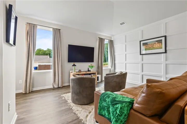 This inviting living area features LVP flooring and large windows, creating a bright and comfortable space.