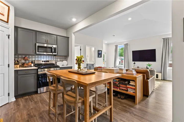 This open concept kitchen and living area features LVP flooring, walk-in pantry and modern appliances.