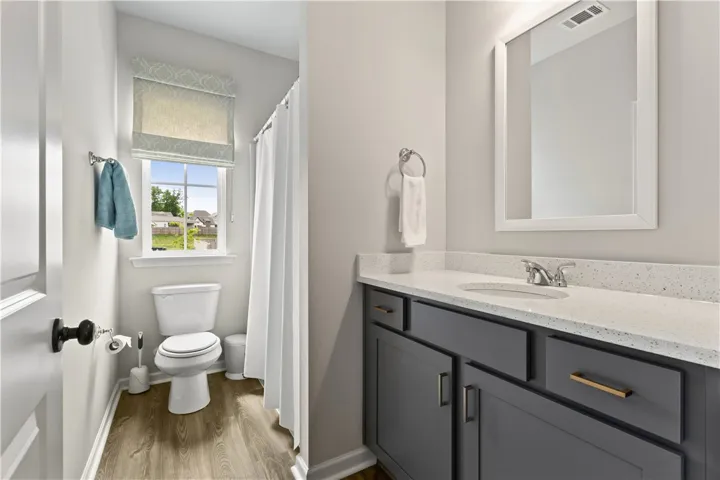 This bathroom features a sleek vanity with ample storage and durable flooring.