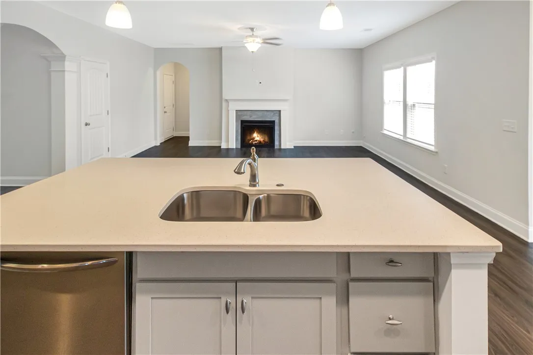 A well-appointed kitchen island offers a dual-basin sink and seamless connection to the living area.