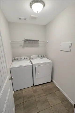 Functional laundry space featuring modern appliances and practical storage shelving.