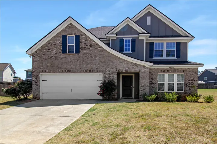 This charming home features a classic brick and siding exterior with an attached garage.