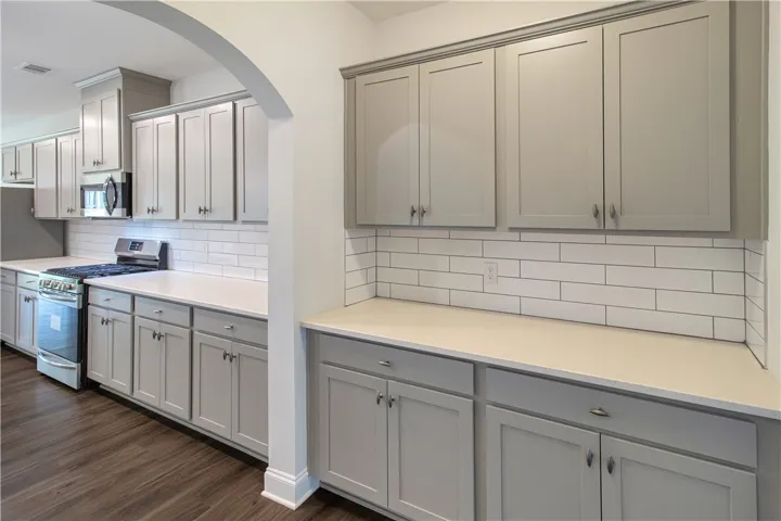 Culinary excellence awaits in this kitchen featuring abundant cabinetry and sleek countertops.