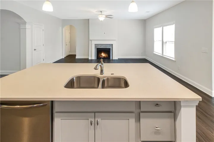 A well-appointed kitchen island offers a dual-basin sink and seamless connection to the living area.