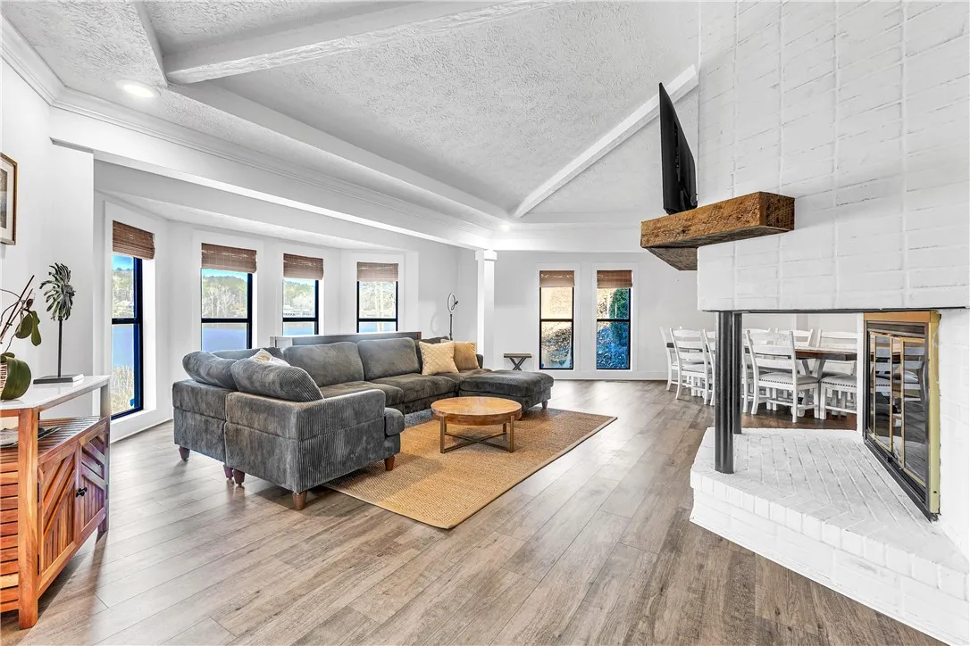 This airy living space features hardwood flooring and an inviting fireplace.