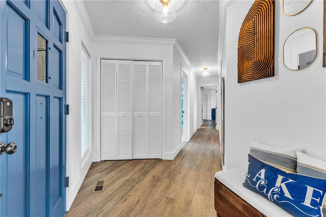 This entry hall features durable flooring and functional storage leading to a bright interior.