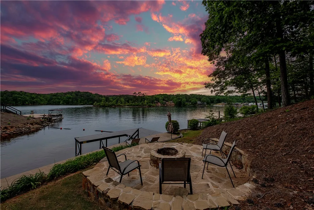 This lakeside setting offers a built-in fire pit, perfect for evening gatherings under colorful skies.