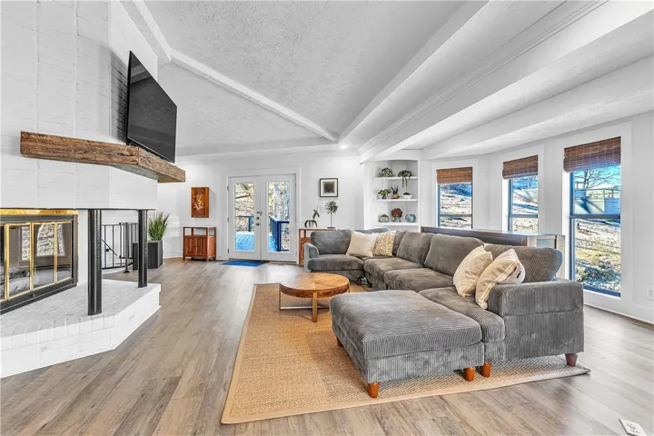 This inviting living area boasts an impressive fireplace and large windows offering abundant natural light.