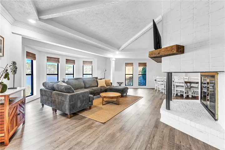 This airy living space features hardwood flooring and an inviting fireplace.
