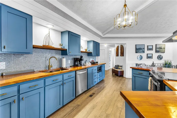 This bright kitchen features custom cabinetry, wood countertops, and modern appliances, creating a welcoming culinary space.