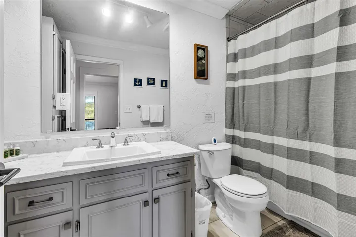 This bright bathroom features a spacious vanity with ample storage and a convenient shower area.