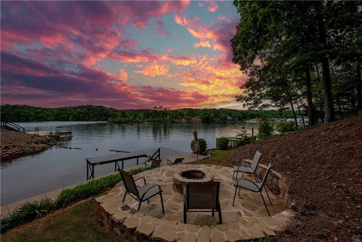 This lakeside setting offers a built-in fire pit, perfect for evening gatherings under colorful skies.