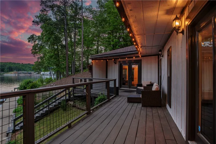 This captivating outdoor deck offers serene lake views and a tranquil forest backdrop, perfect for relaxation.