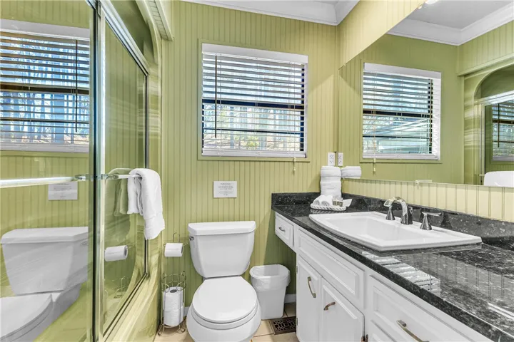 This bright bathroom features a spacious vanity with ample storage and a refreshing shower enclosure.
