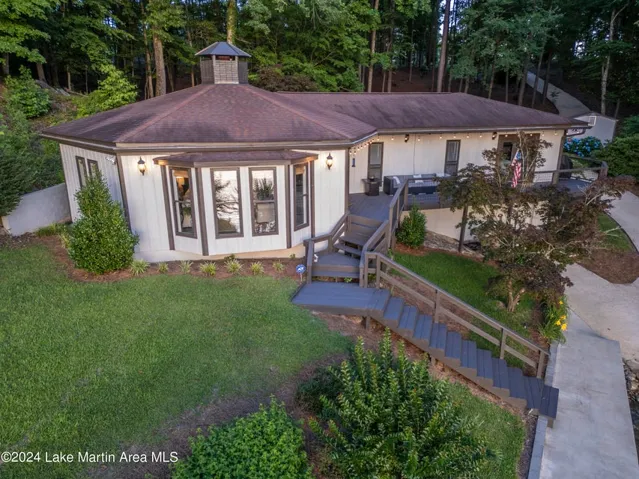 This charming lakeside dwelling is nestled among lush trees, offering a private retreat.