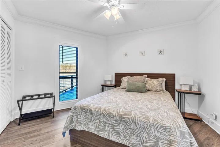 This cozy room features a ceiling fan, a window, and durable flooring, creating a comfortable living space.