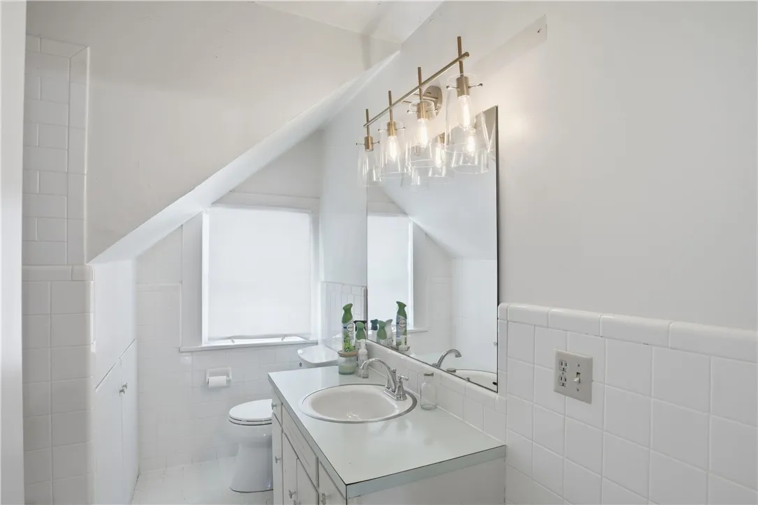 This bright bathroom features sloped ceilings and ample light, ideal for peaceful mornings.
