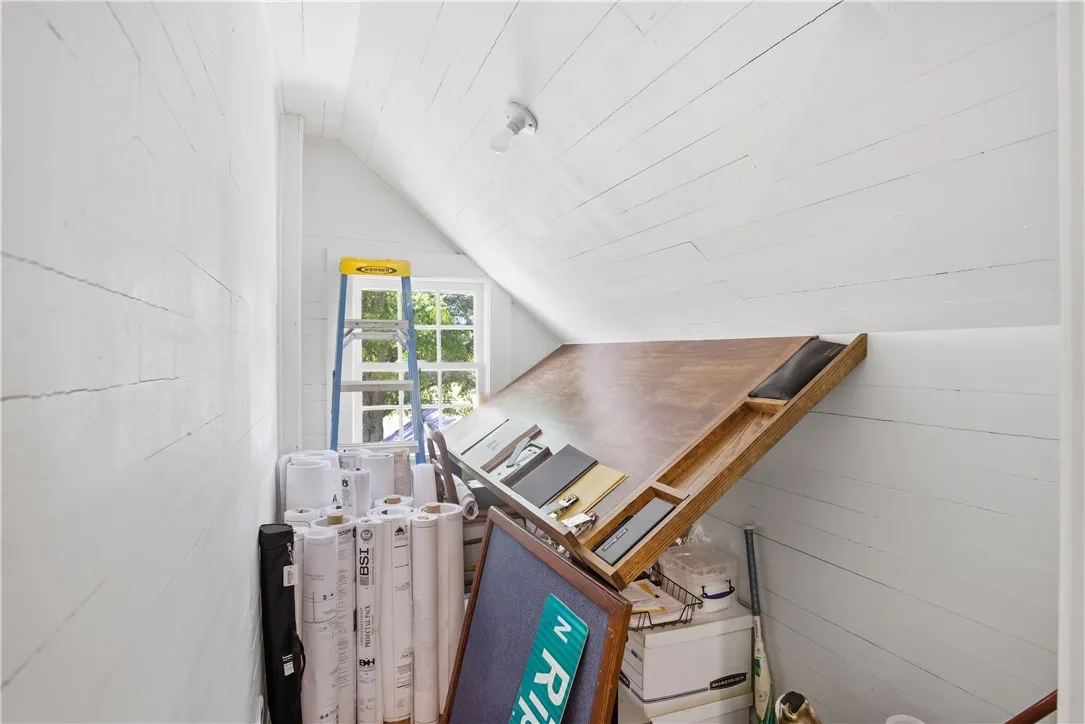This bright attic space offers potential for creative pursuits or organized storage solutions.