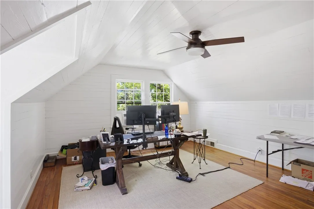 This bright office space features beautiful hardwood flooring and charming sloped ceilings.