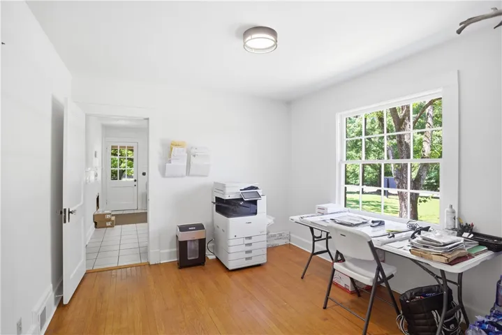 Bright and airy office space features ample natural light and polished hardwood flooring.