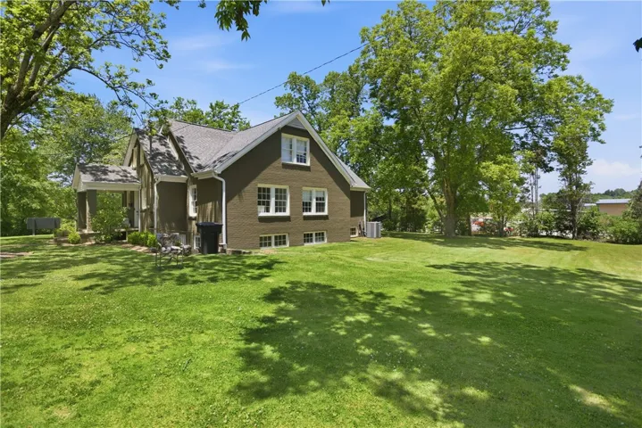 This house features a charming porch and a spacious yard, creating an inviting outdoor living space.