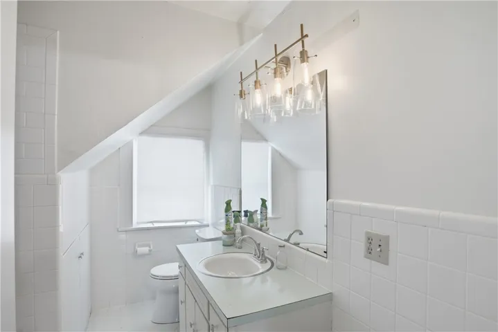 This bright bathroom features sloped ceilings and ample light, ideal for peaceful mornings.