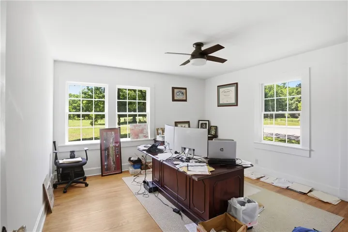 This bright office space features large windows overlooking a scenic outdoor landscape.