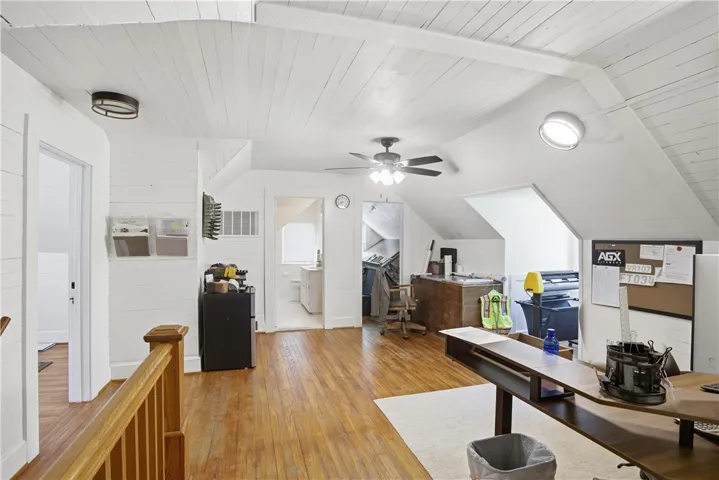 This versatile attic space features vaulted ceilings and warm wood flooring.
