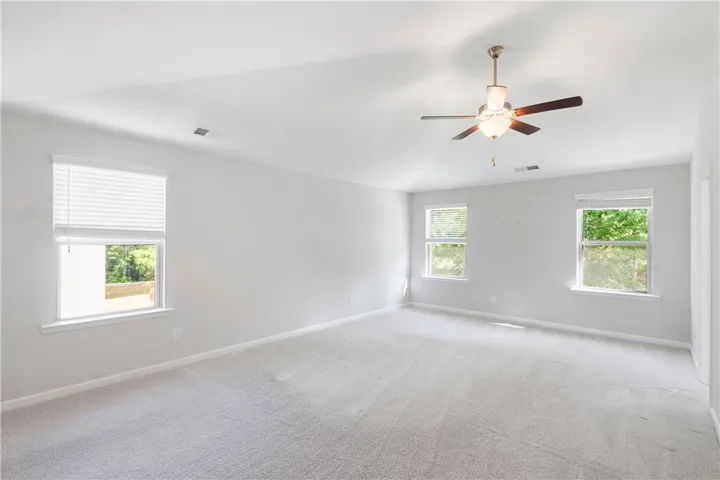 This airy bedroom features vaulted ceilings and ample natural light, perfect for serene living.