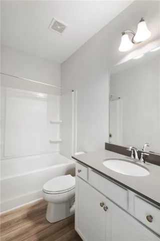 This bathroom features a contemporary vanity and practical tub-shower combination.