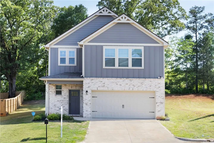 This contemporary home features a striking facade, an attached garage, and a lush, private yard.