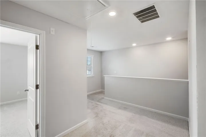This versatile loft area offers a flexible space, ideal for various uses, with natural light and plush carpeting.