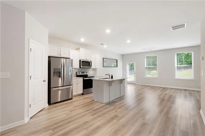 Bright and open-concept living space with a modern kitchen island and elegant wood flooring.