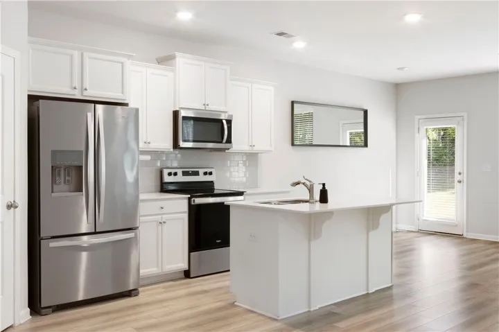 This bright kitchen features modern appliances and a functional island, perfect for culinary endeavors.