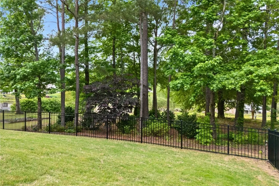 The lot go beyond the trees to the sidewalk